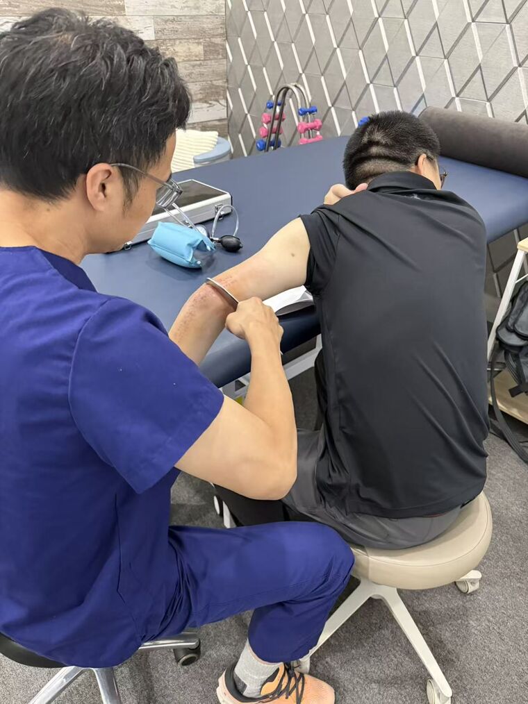 Dr. Zhan treating a patient’s arm